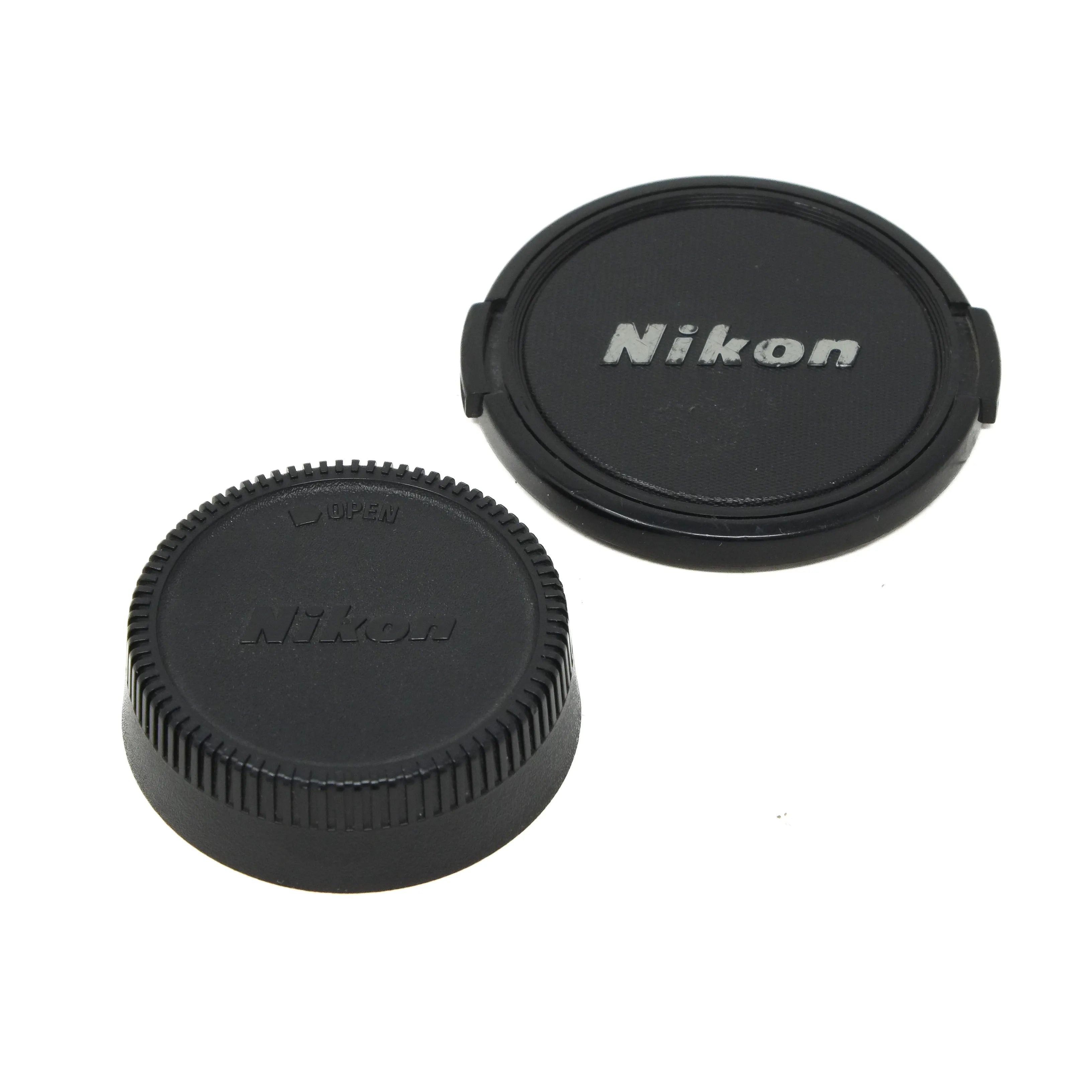 Two Nikon camera lens caps on a white background