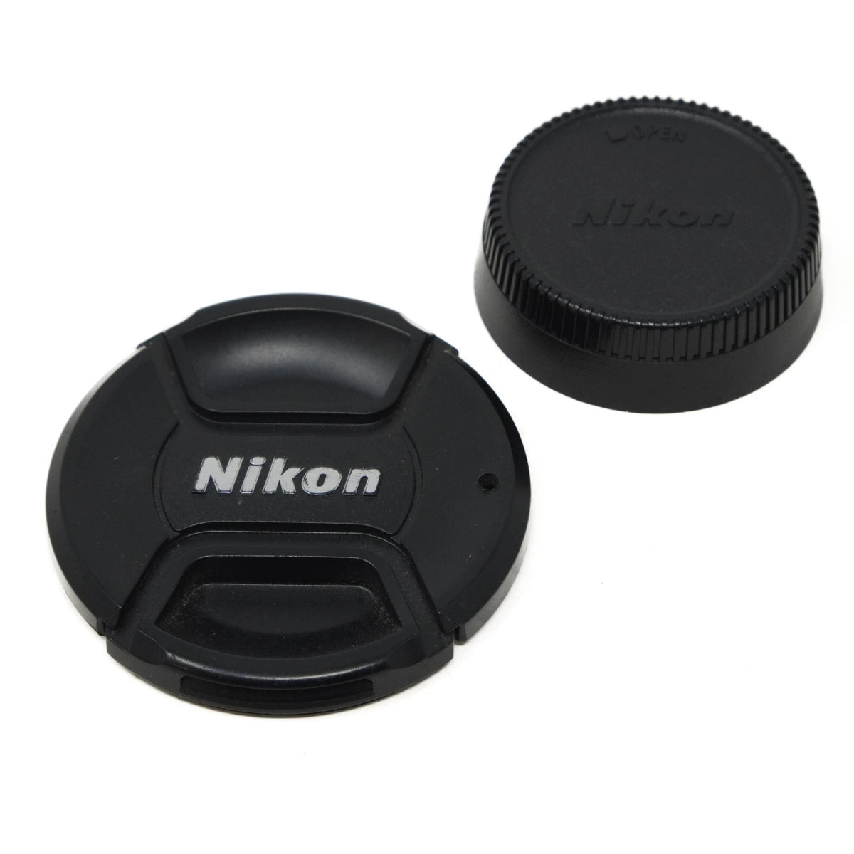 Two Nikon lens caps on a white background