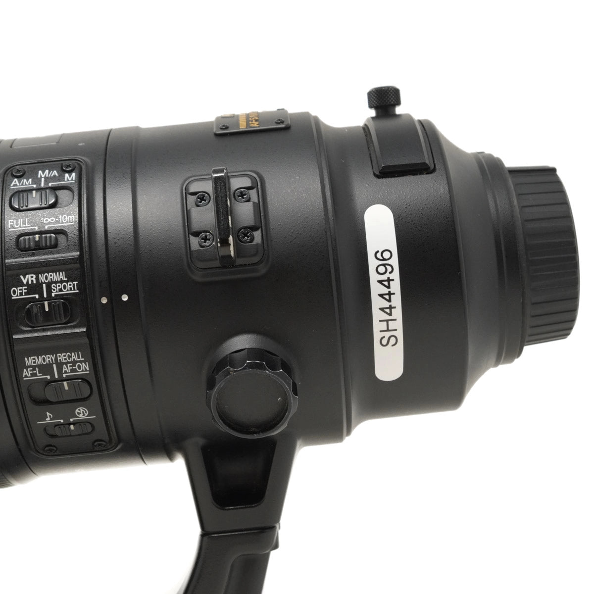Close-up of a black camera lens with control buttons on a white background