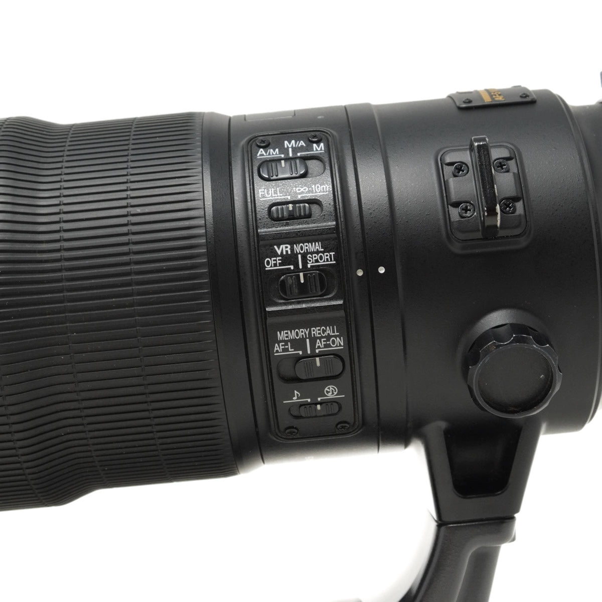 Close-up of a camera lens with control buttons on a white background