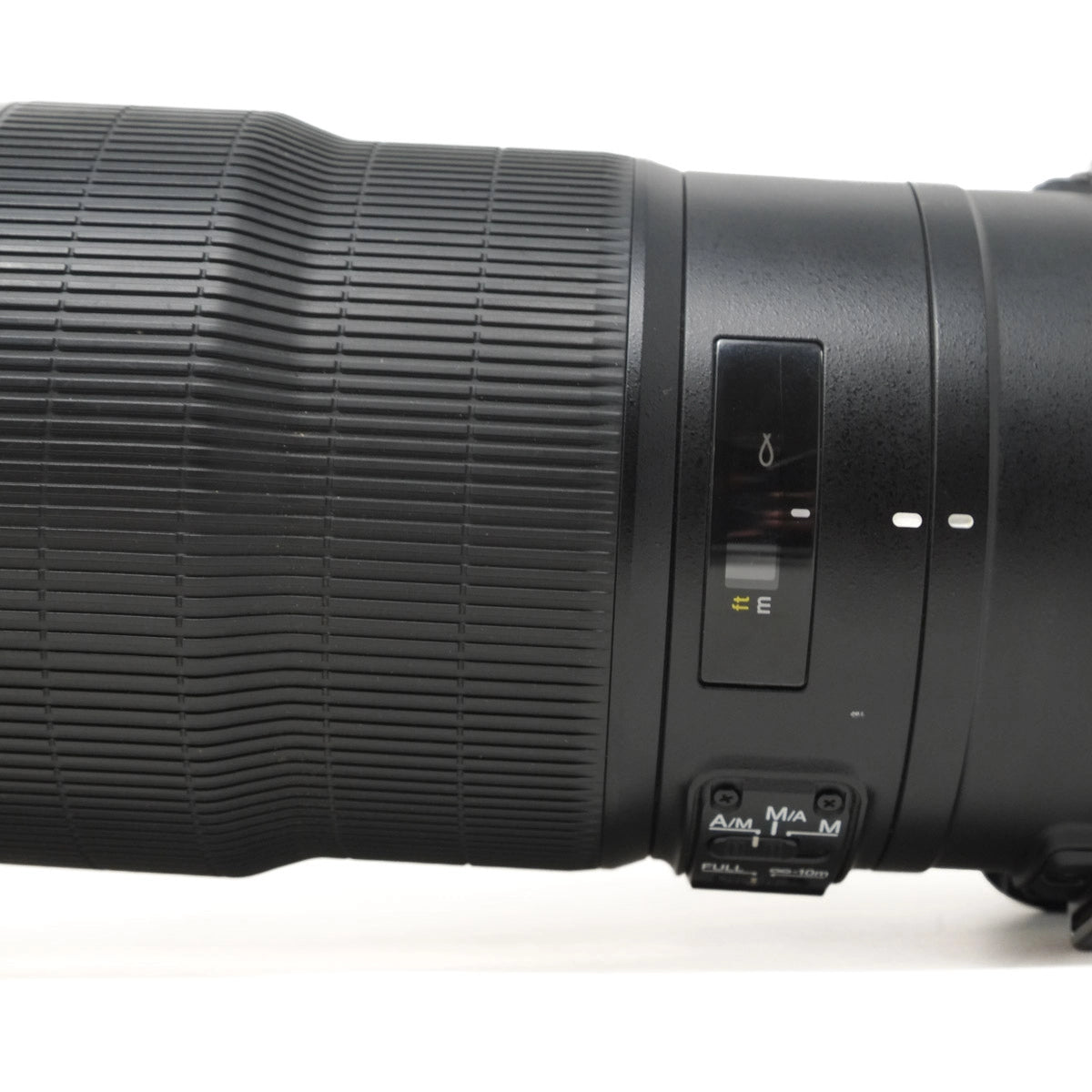 Close-up of a camera lens with control buttons on a white background