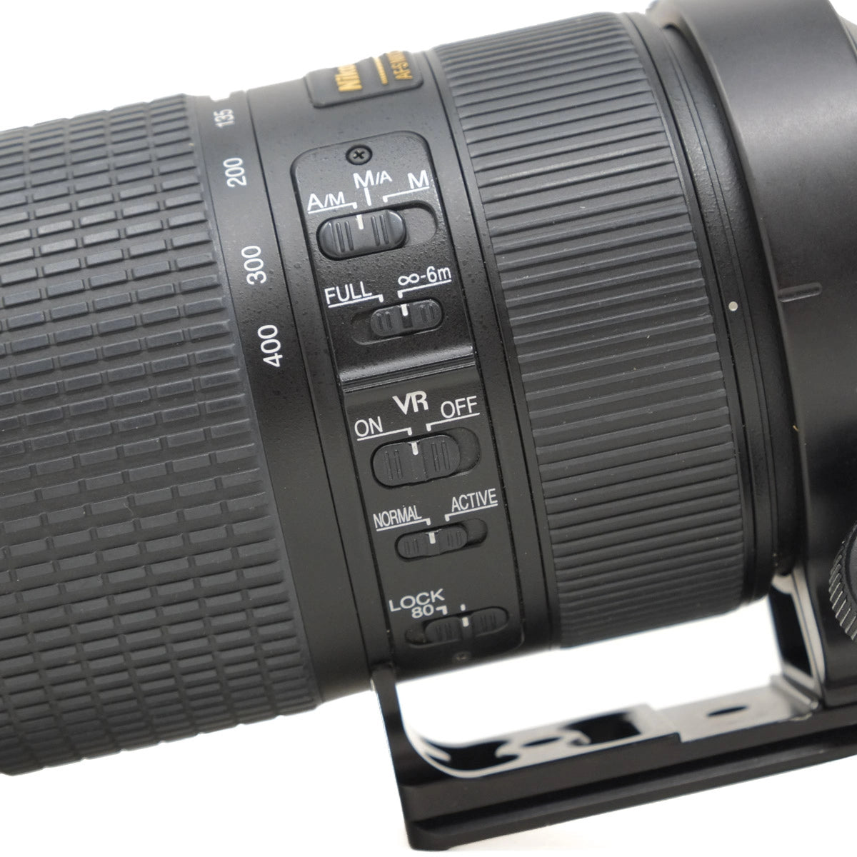 Close-up of a camera lens with control buttons on a white background