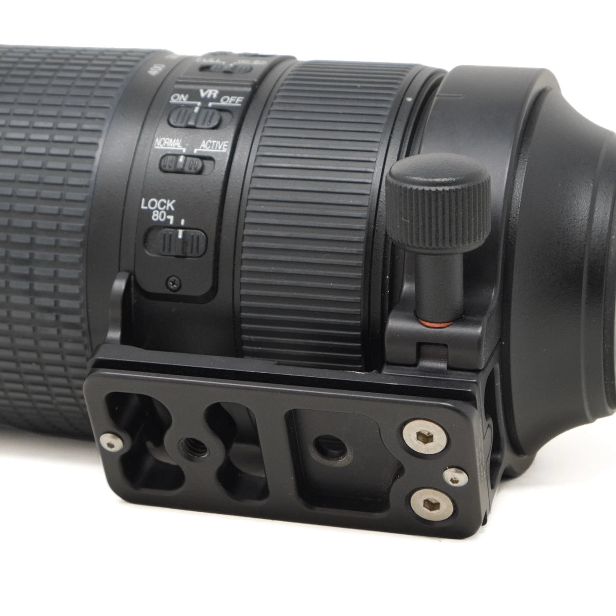 Close-up of a black camera lens with control buttons on a white background