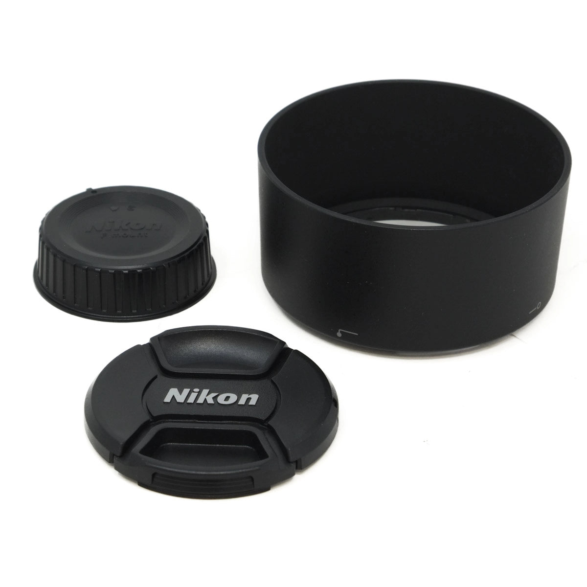 Nikon camera lens accessories including a lens hood, lens cap, and front lens cap on a white background.