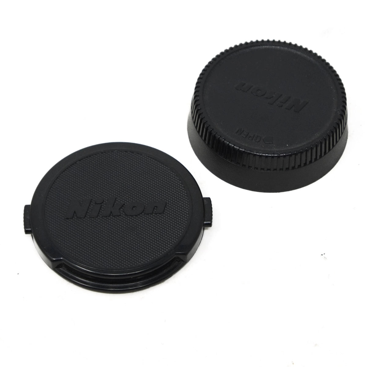 Two black Nikon camera lens caps on a white background