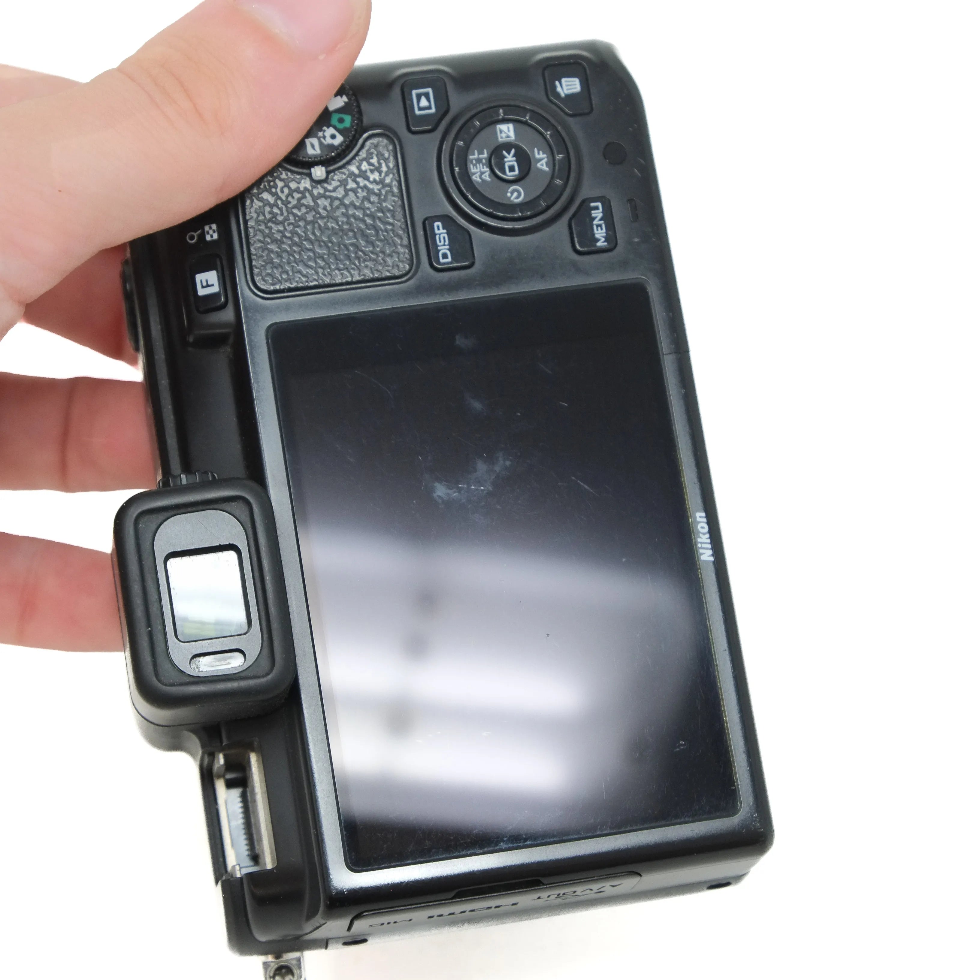 Digital camera held by a hand with a white background