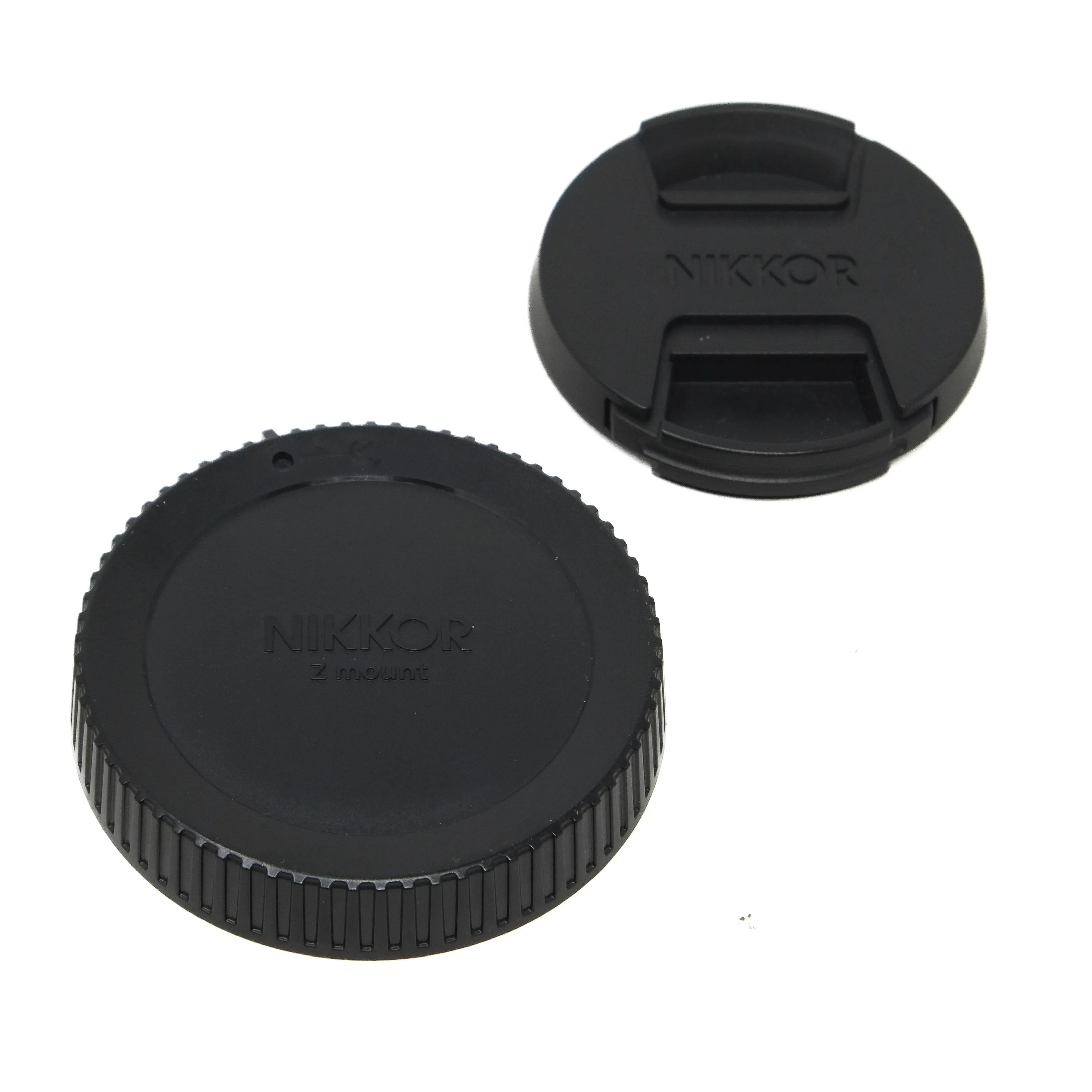 Two black Nikon lens caps on a white background