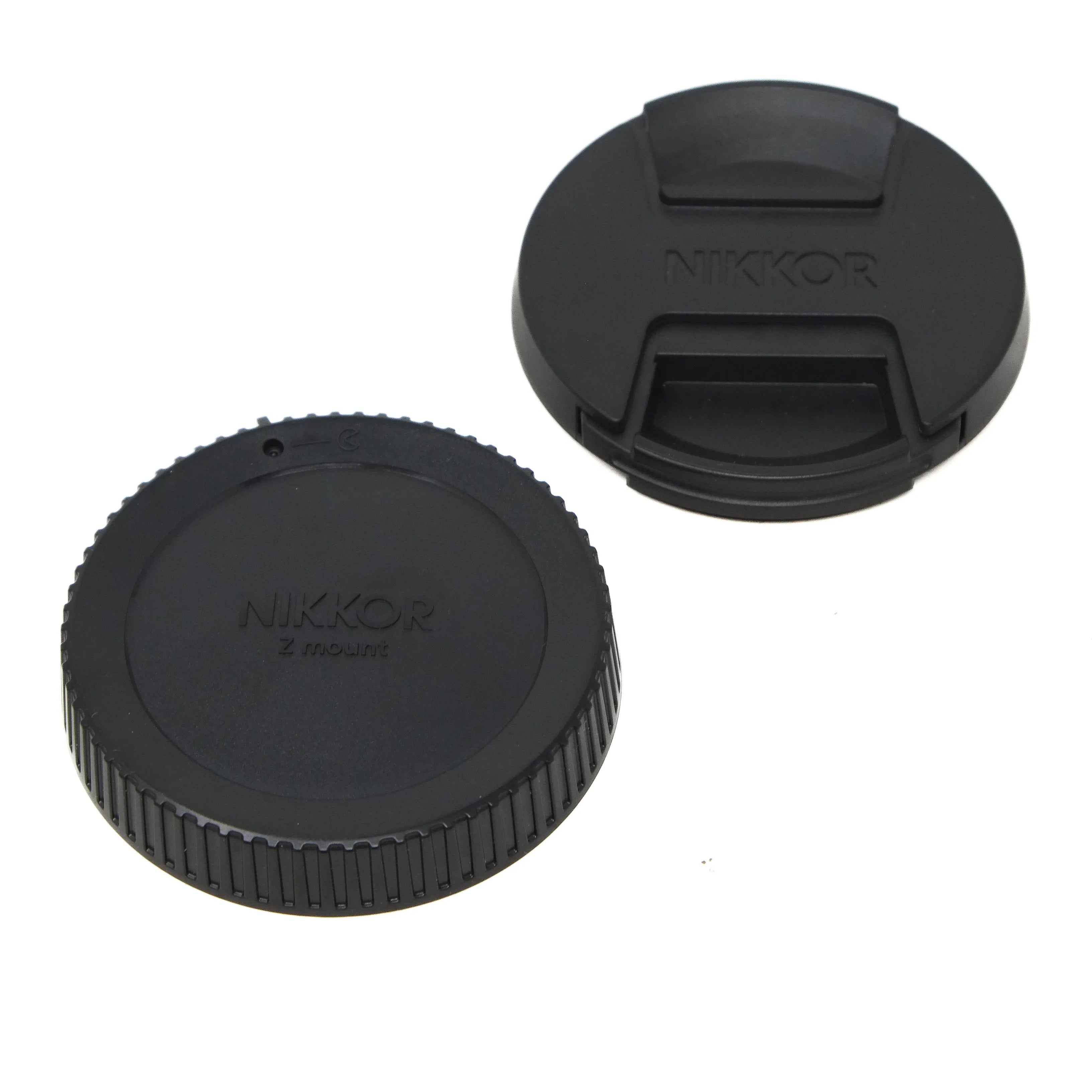 Two black Nikon lens caps on a white background