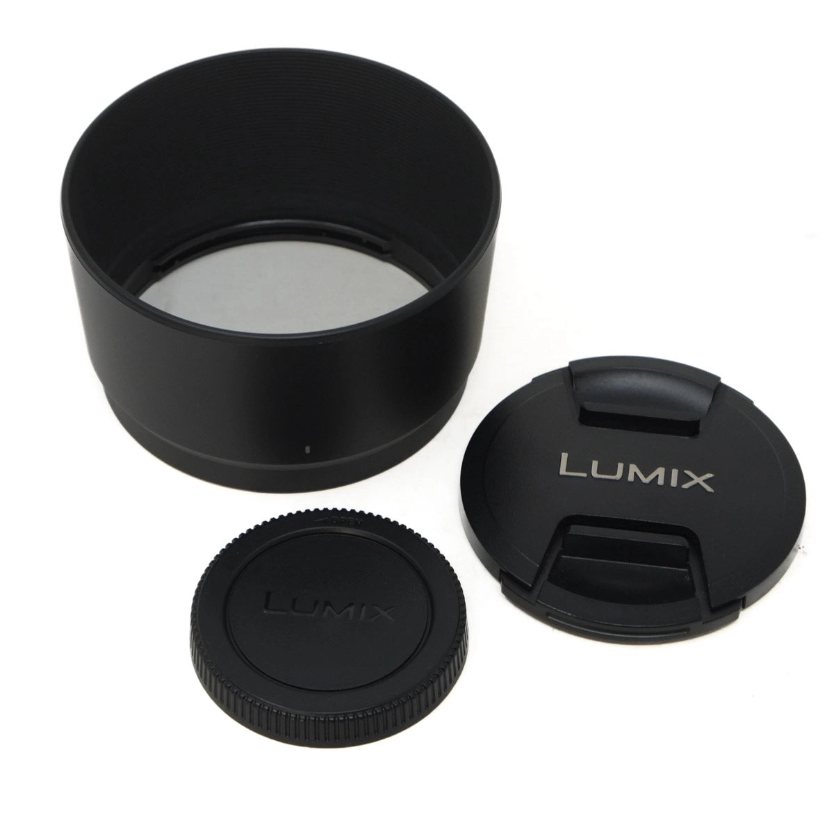 Set of black camera lens accessories with 'LUMIX' branding on a white background