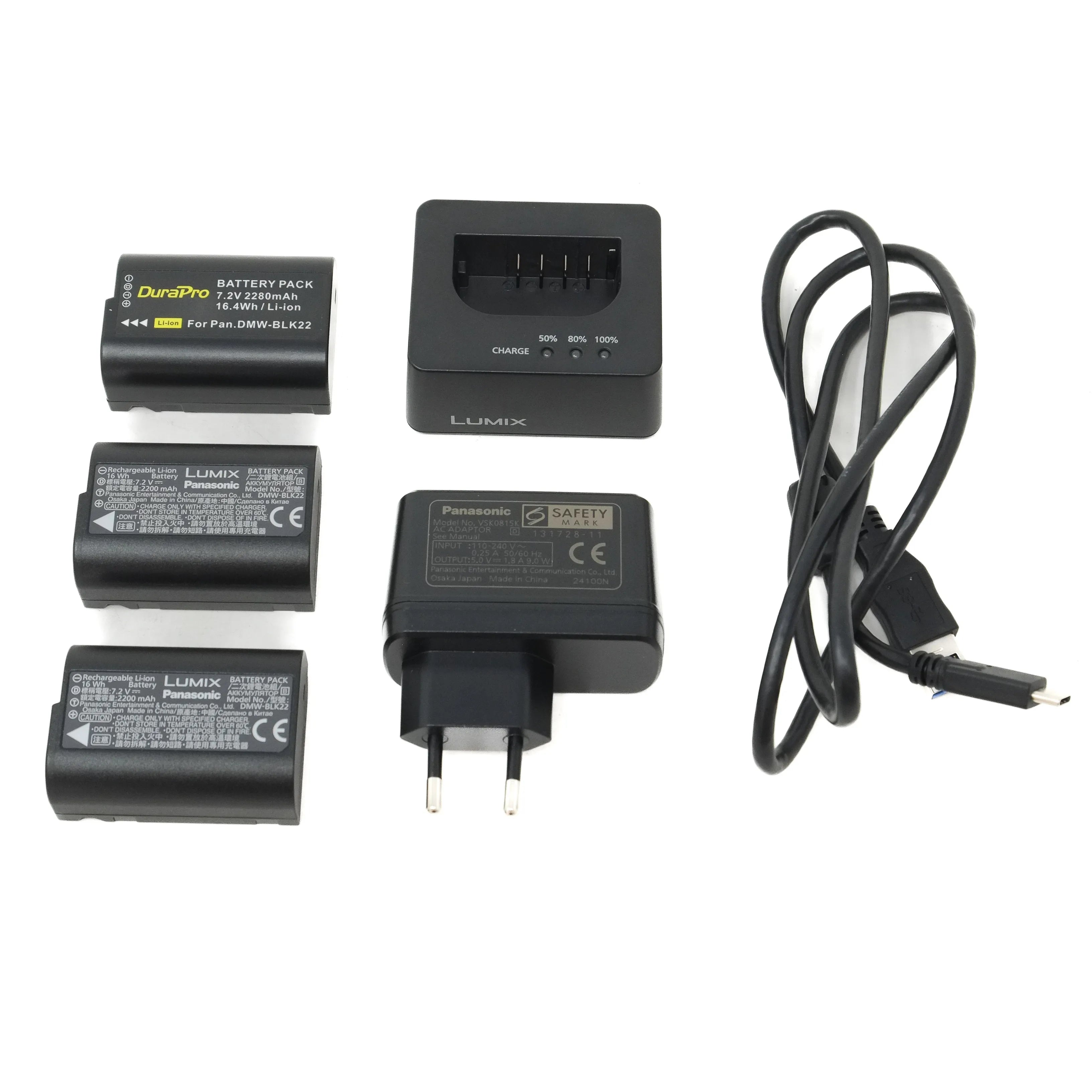 Set of batteries, charger, and cable on a white background