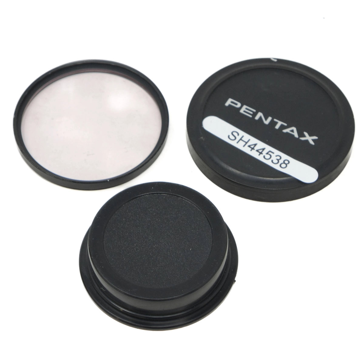Pentax camera lens caps and filter on a white background