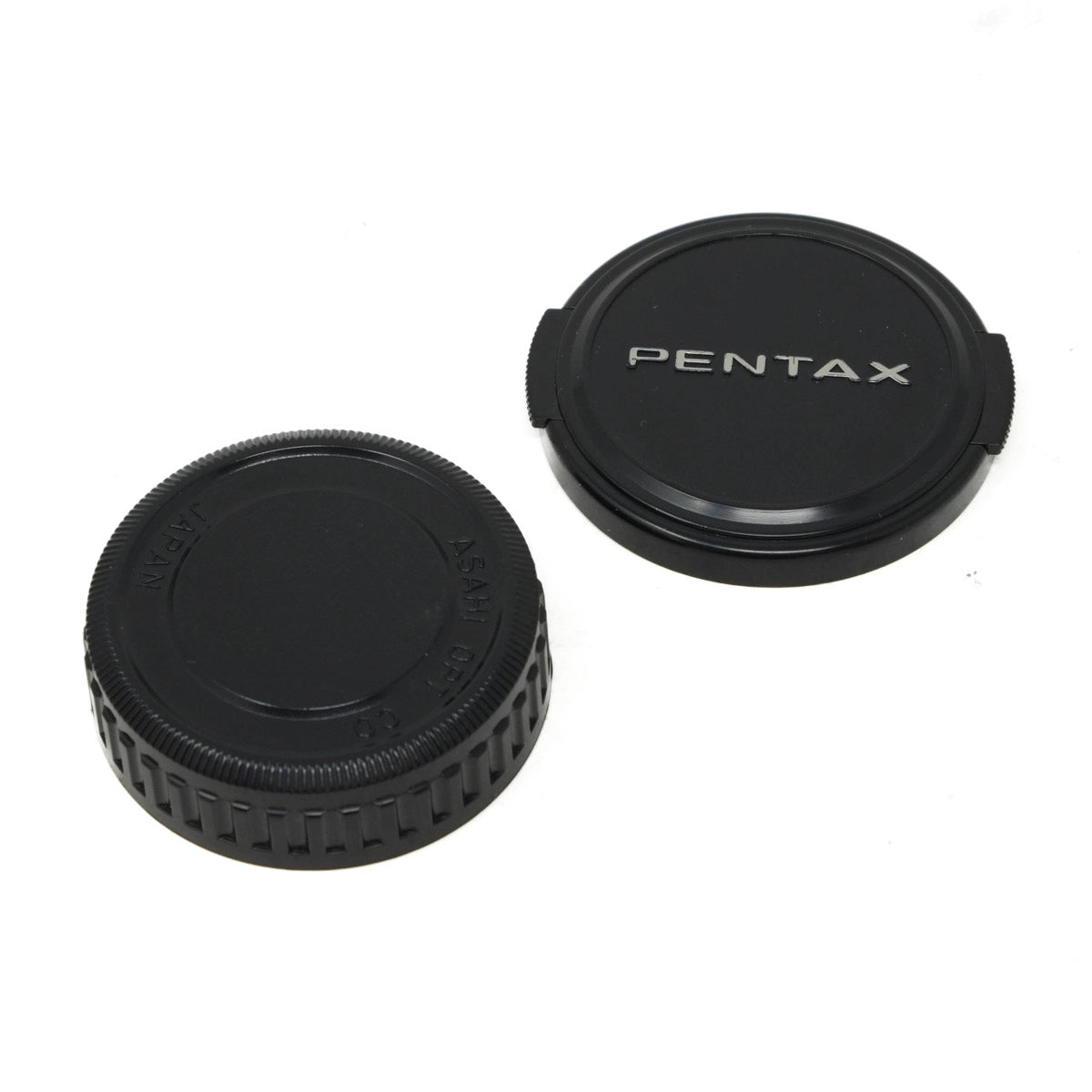 Two black Pentax camera lens caps on a white background