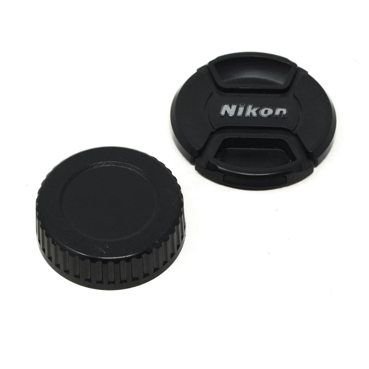 Two black camera lens caps with Nikon branding on a white background