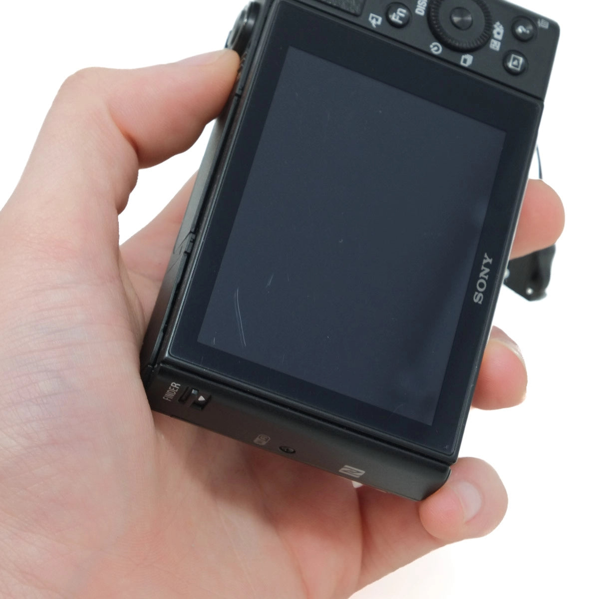 Hand holding a Sony camera with a white background