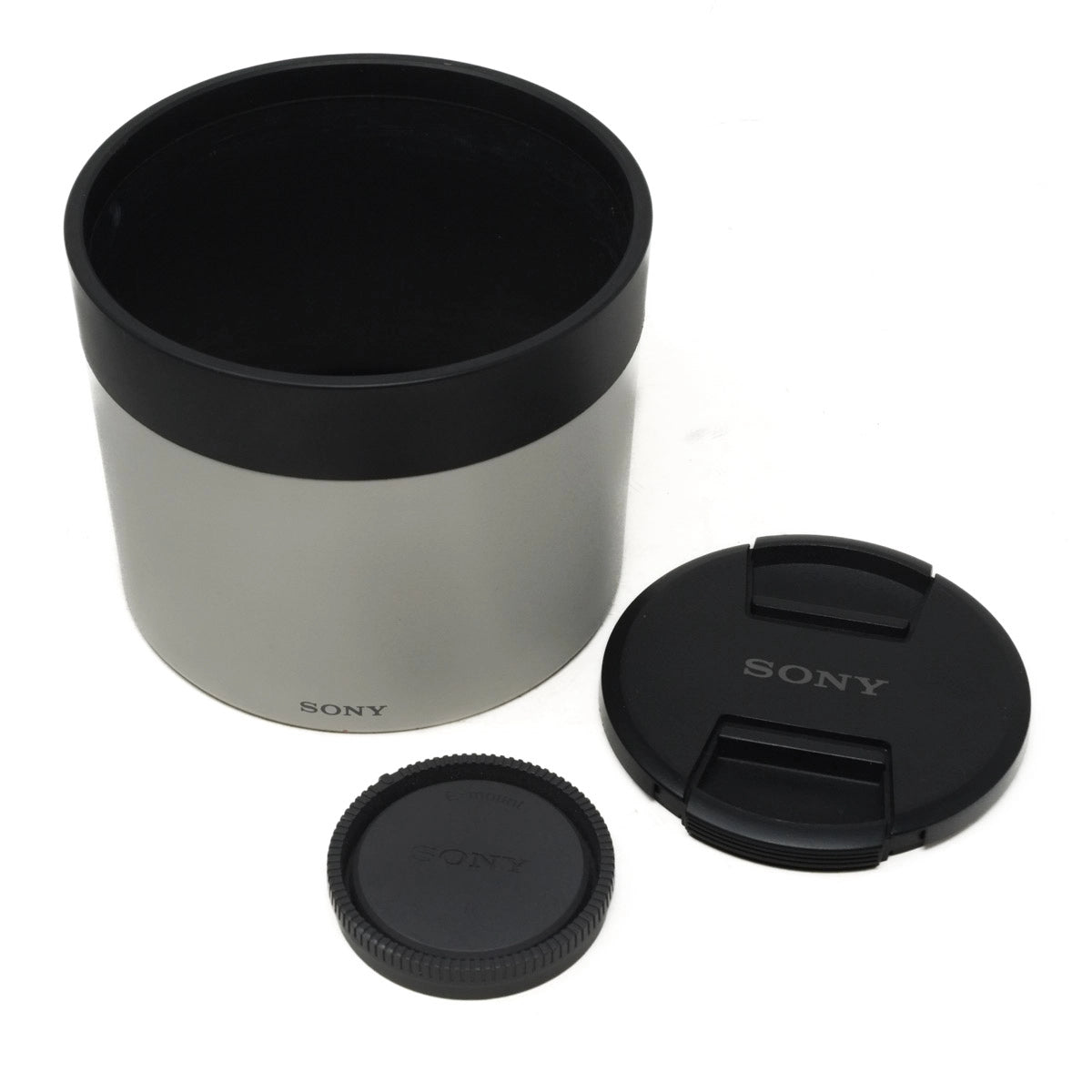 Sony camera lens with two lens caps and a lens hood on a white background
