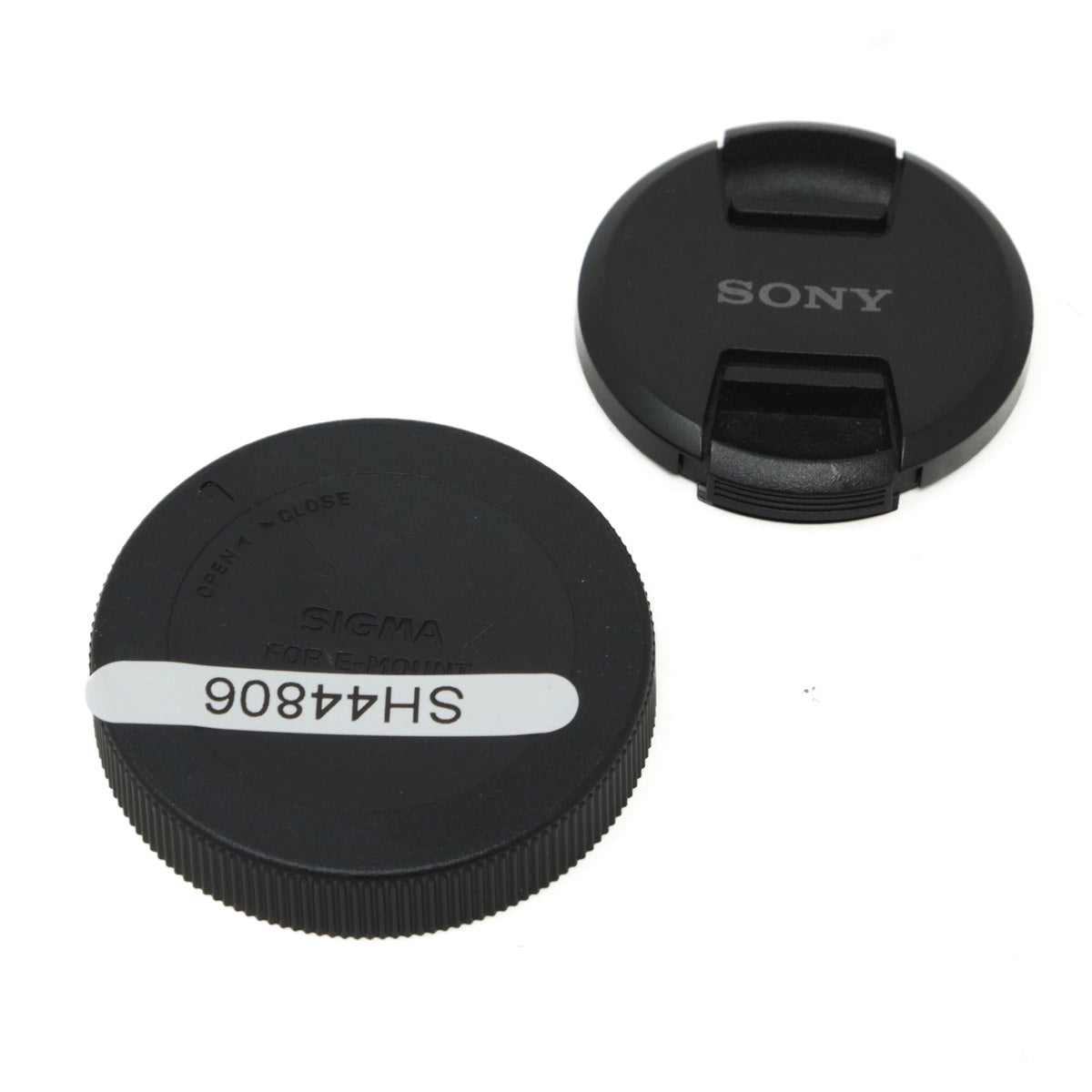 Two black camera lens caps with 'Sony' and 'Sigma' branding on a white background.