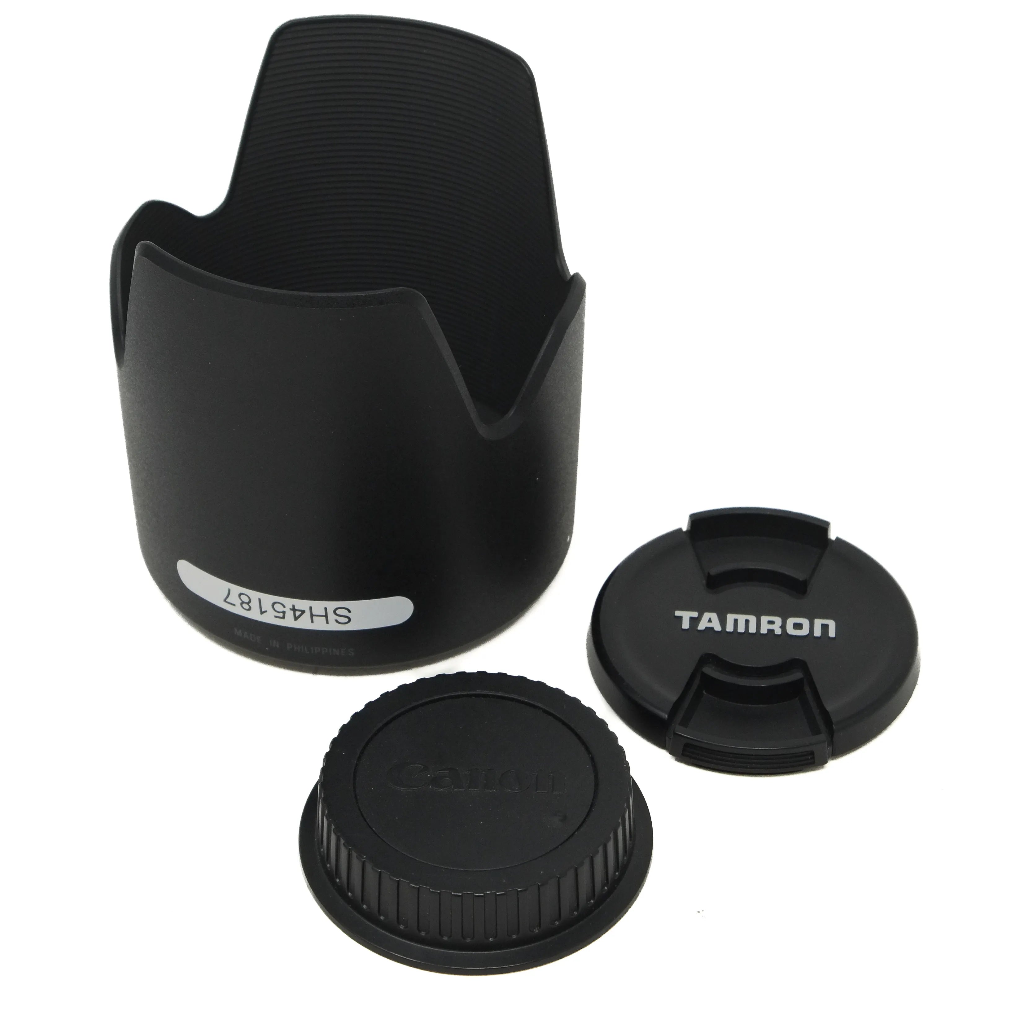 Camera lens hood and caps with Tamron branding on a white background