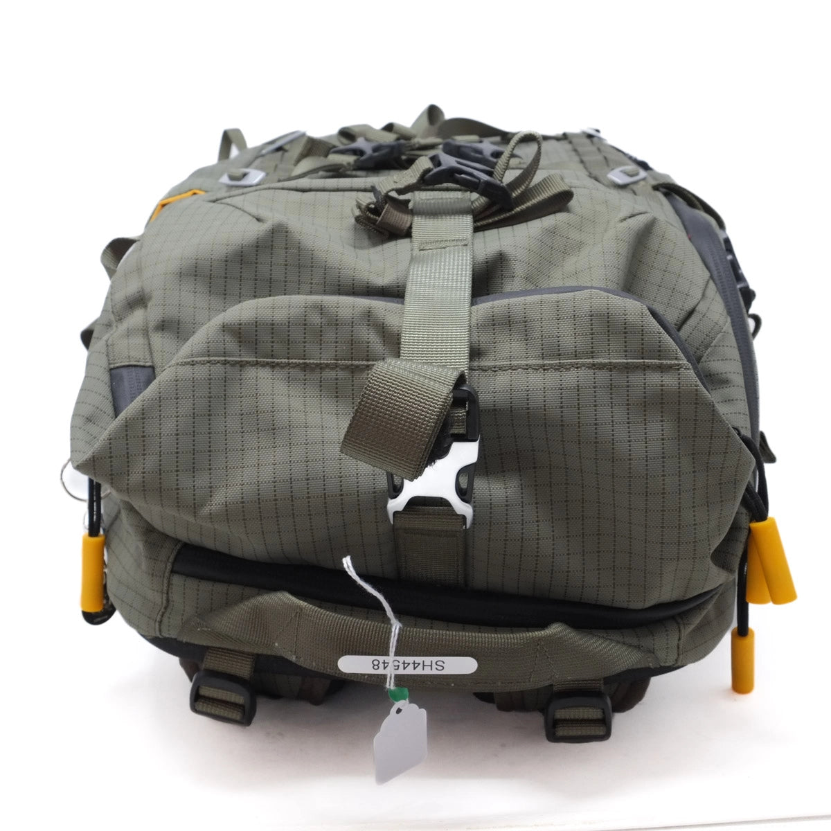 Green tactical backpack with visible branding on a white background