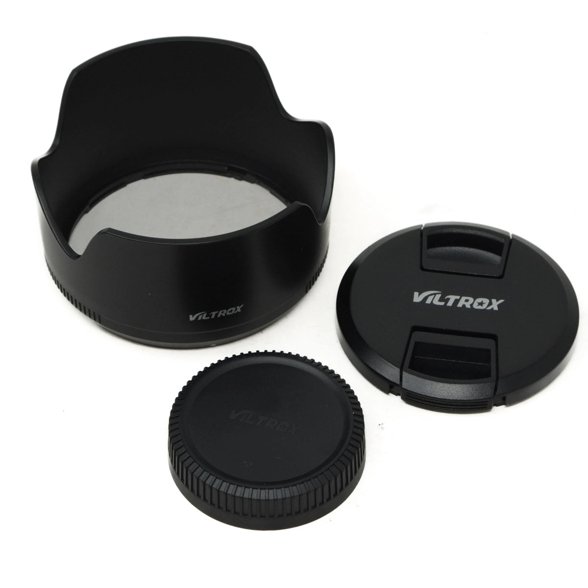 Set of Viltrox camera lens accessories including a lens hood, front cap, and rear cap on a white background.