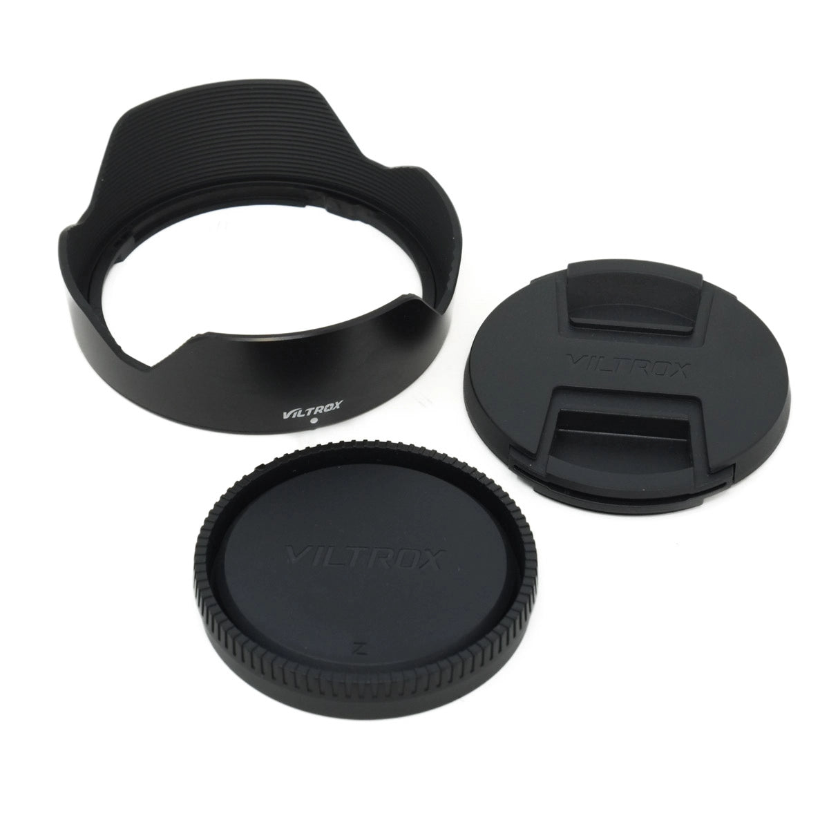 Camera lens accessories including a hood, front cap, and rear cap on a white background