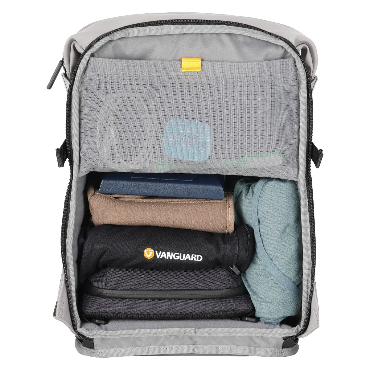 Open backpack with folded clothes and a visible Vanguard logo on a white background