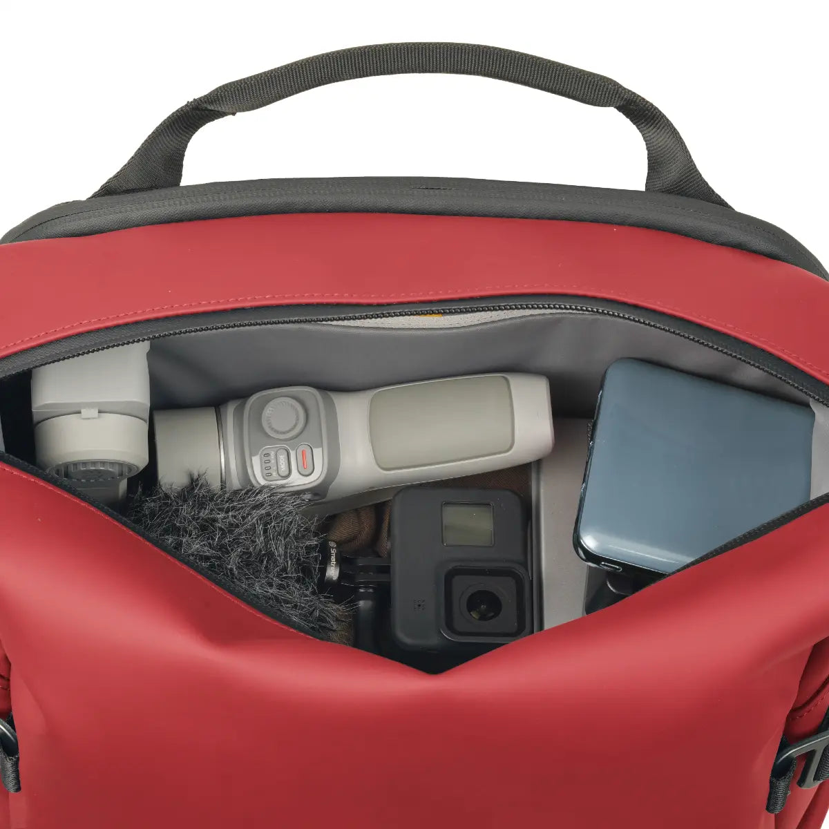 Red backpack with camera equipment inside on a white background