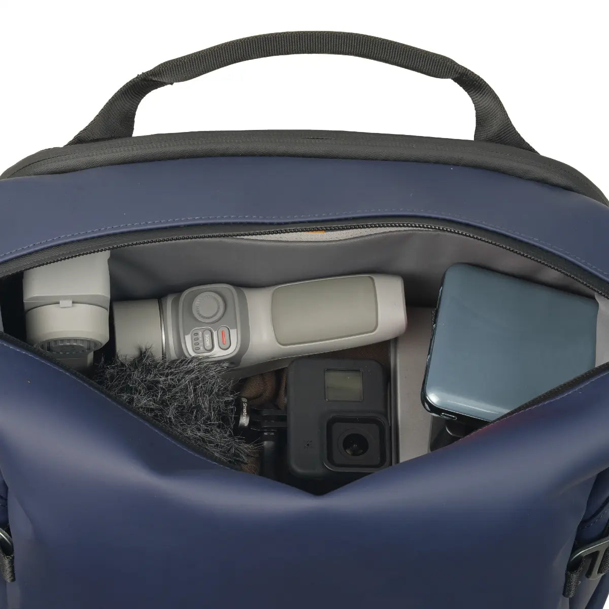 Navy blue backpack with camera equipment inside on a white background