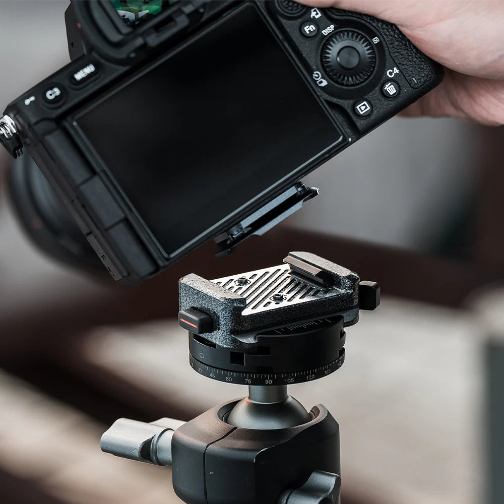 Camera with a mounted quick release plate on a blurred background