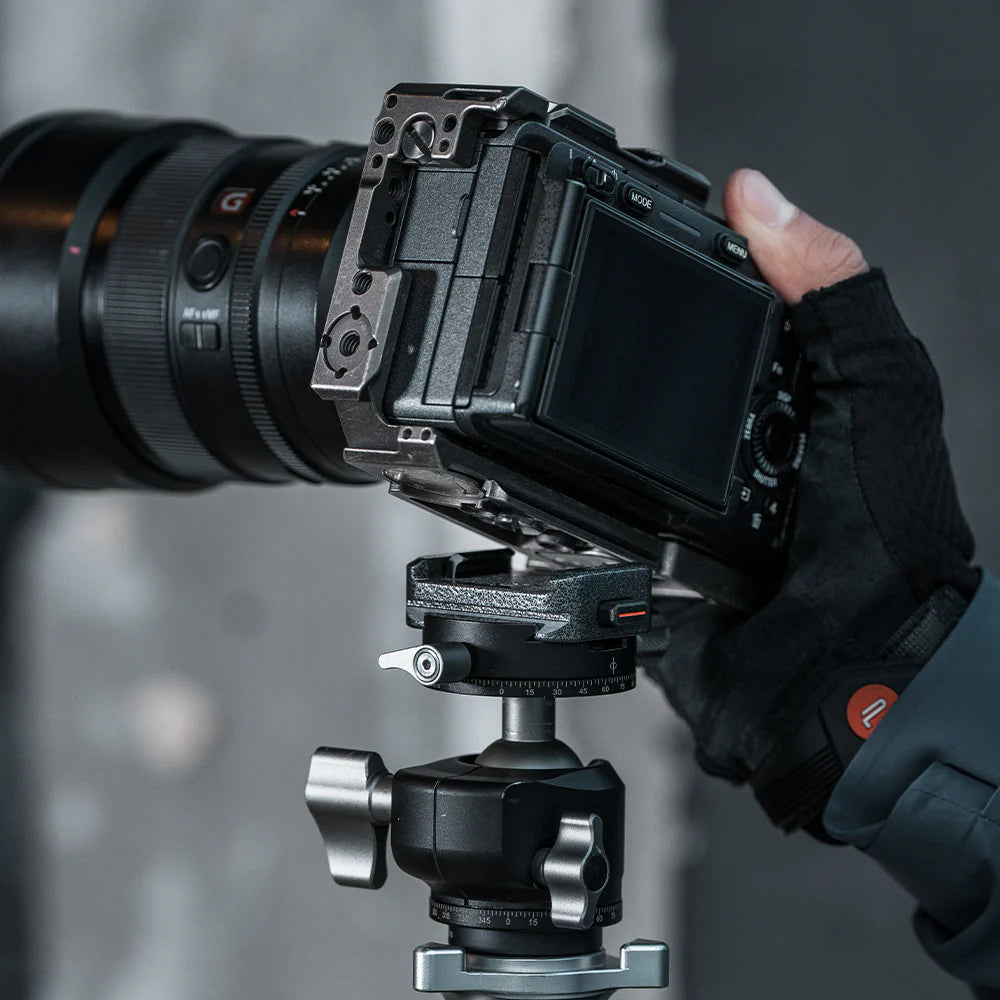 Camera mounted on a tripod with a person adjusting the camera settings