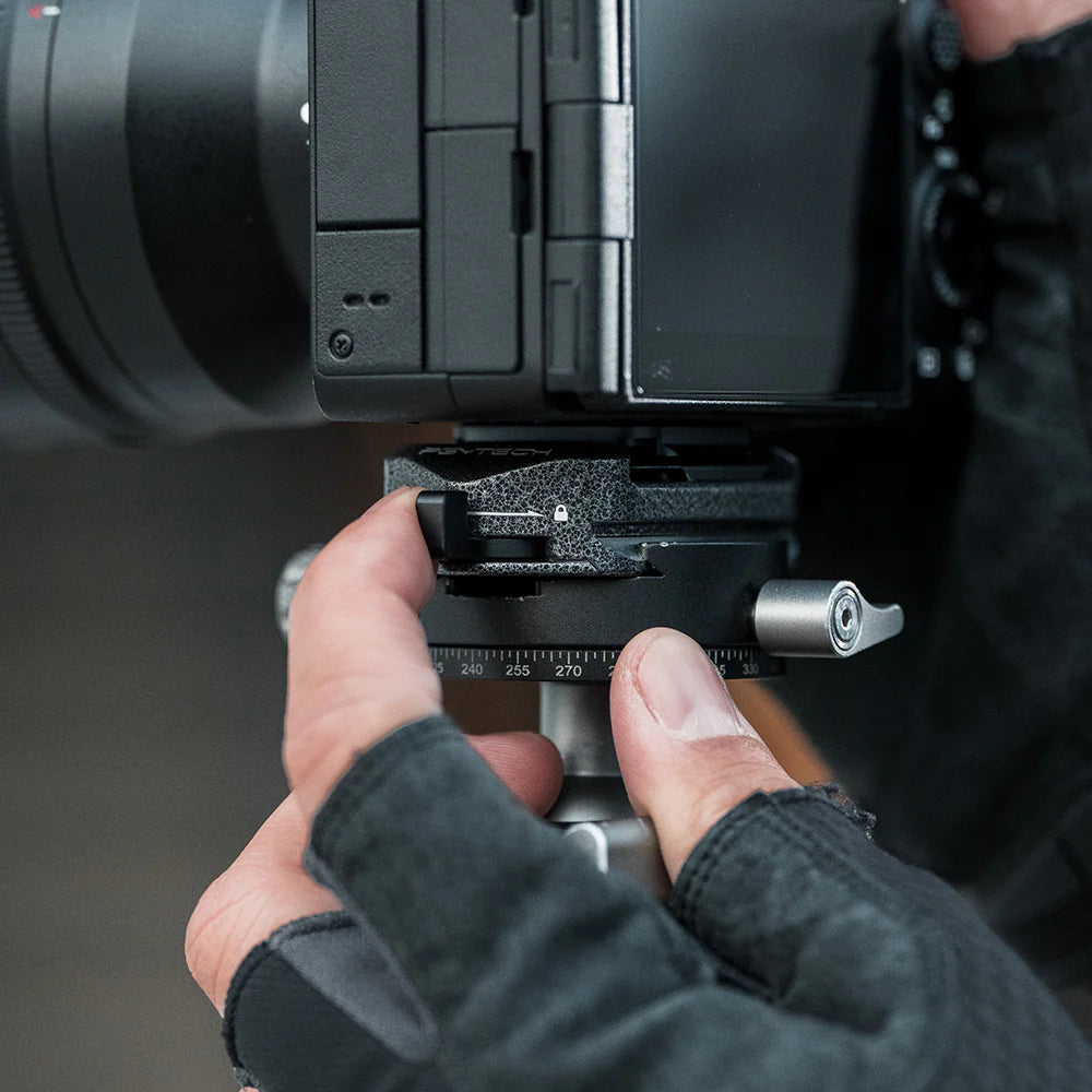 Close-up of a person adjusting a camera lens on a tripod