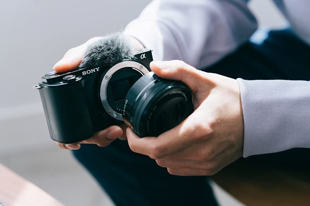 Sony Alpha ZV-E10 APS-C vlog camera with 16-50mm lens - Lifestyle photo of the lens being attached